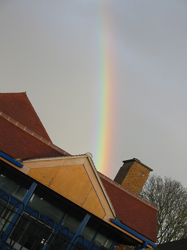 A rainbow above a roof, with a diagonal perspective