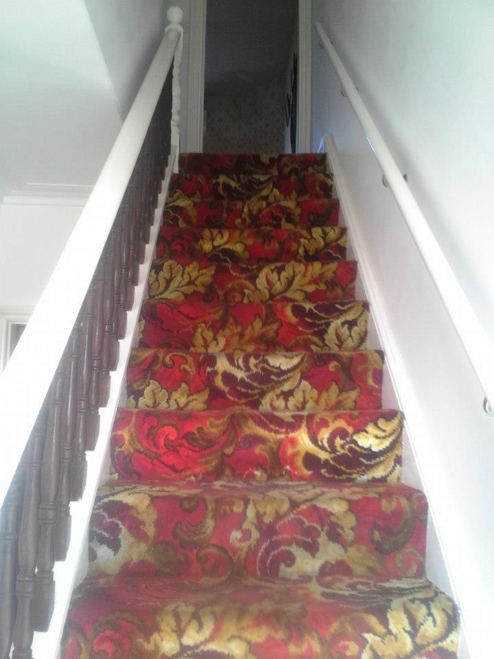Stairs with a deep red flowered carpet